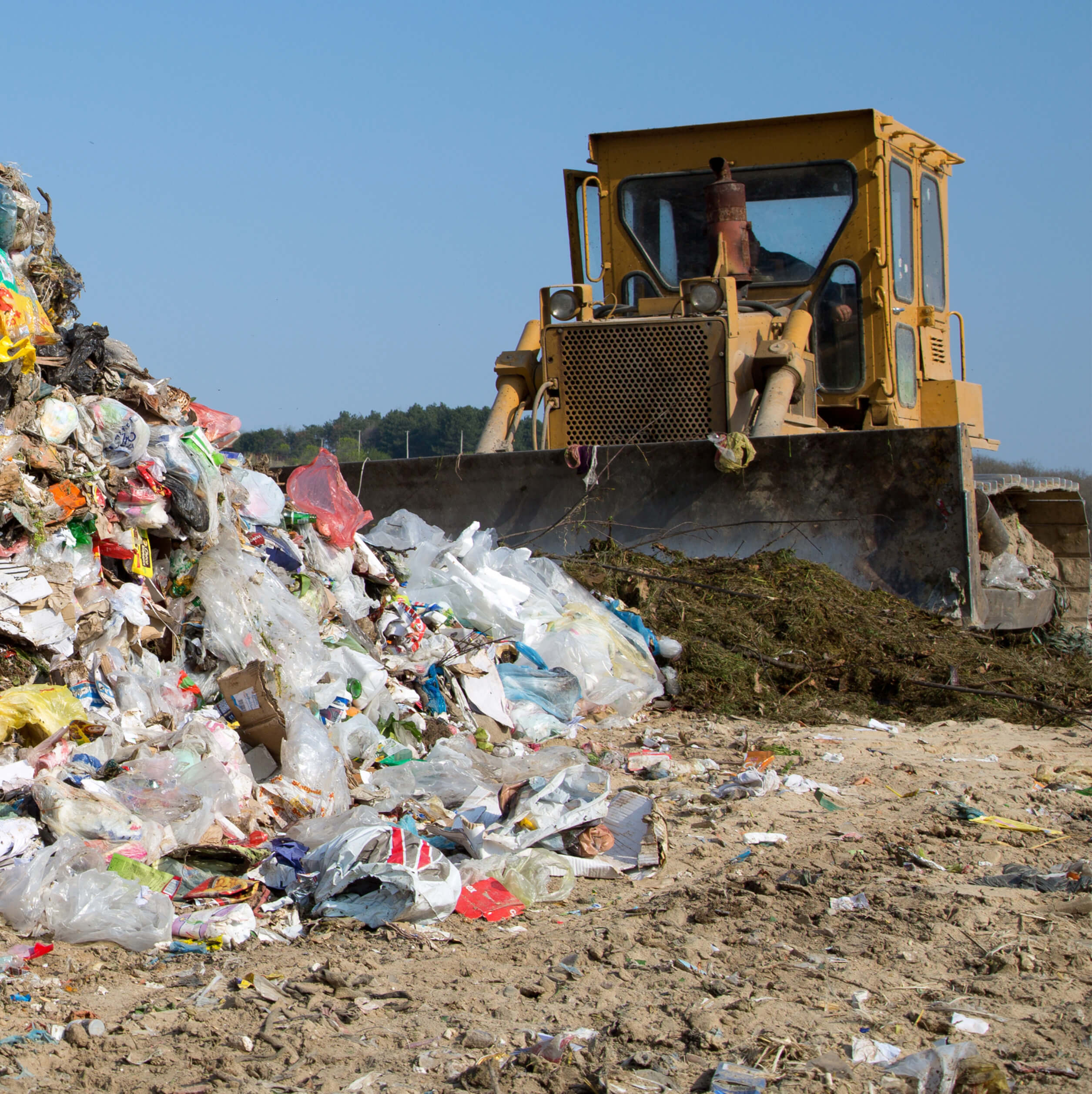 Bulldozer moving waste in a landfill