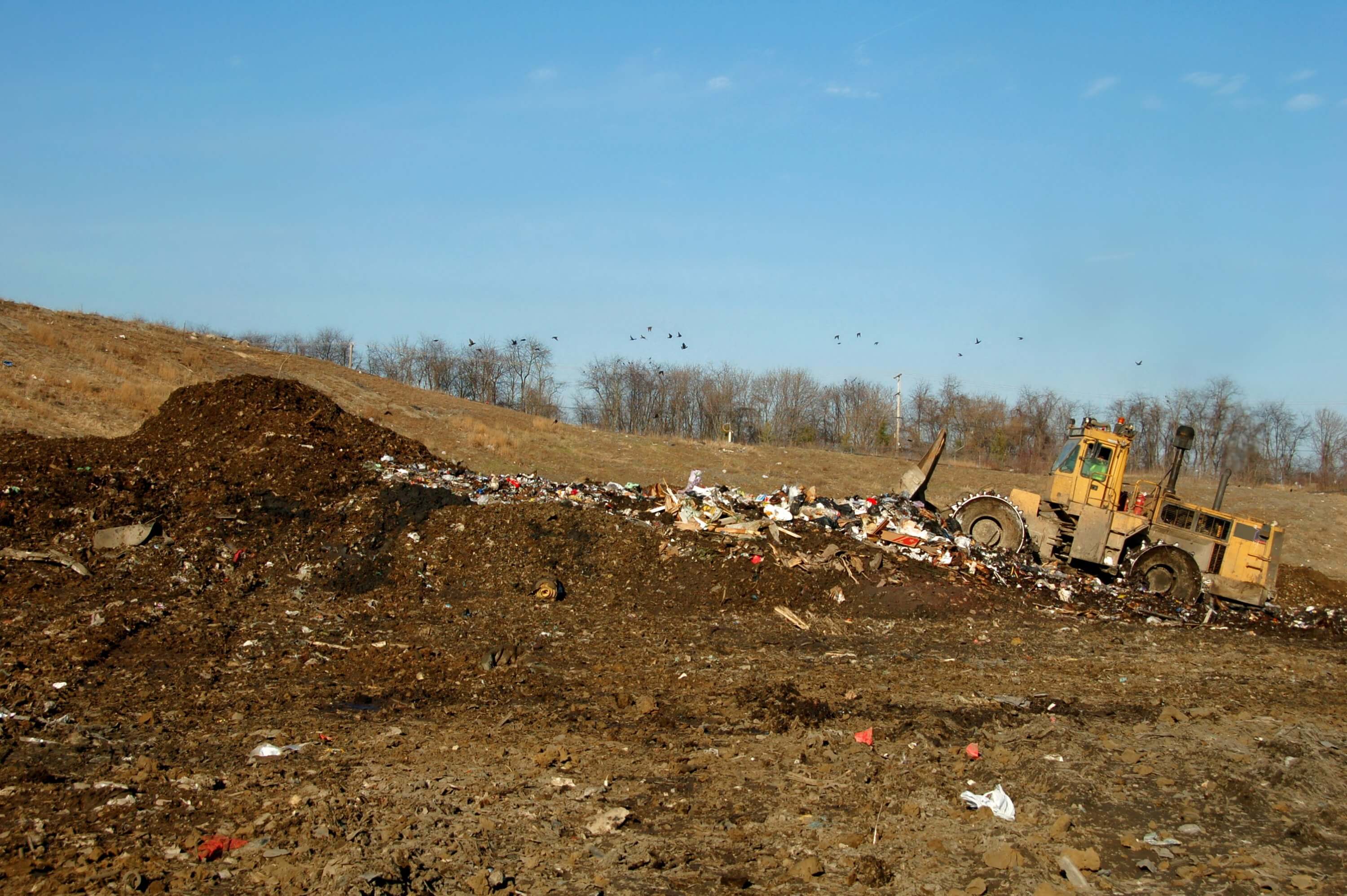 Landfill compactor driving around the landfill to push down and crush garbage